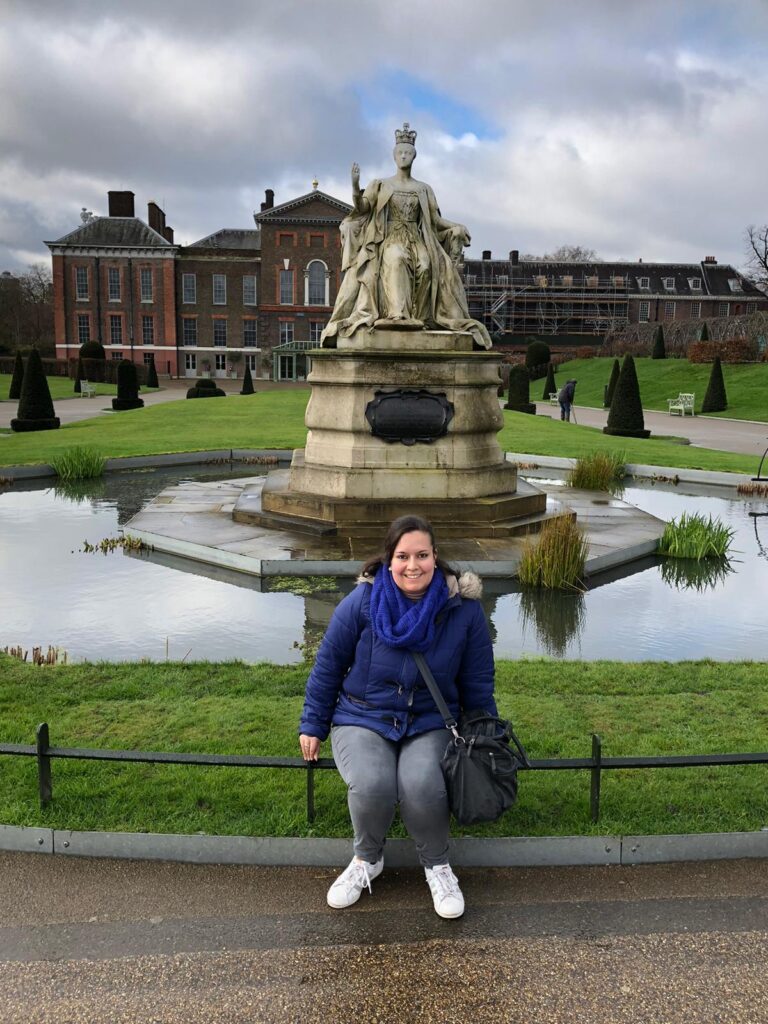 me sittiing in front of the queen victoria statue at kensington palace